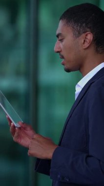Adanmış ve odaklanmış bir profesyonel modern ofis ortamında tablet cihazıyla sorunsuz bir şekilde etkileşir