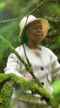 Huzurlu ve huzurlu bir görüntü. Hayat ve renklerin bol olduğu canlı bir ormanda eğlenen bir kadın.