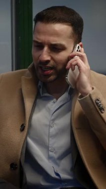 Kendini işine adamış ve odaklanmış bir profesyonel, çağdaş bir ortamda önemli bir telefon görüşmesi yapmaktadır.