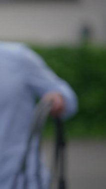 Çevresi yeşilliklerle çevrili bir bahçe hortumunu tutan bir insan dışarıda neşe dolu ferahlatıcı bir anın tadını çıkarır.