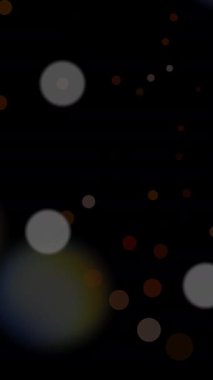 Karanlık arka plandaki yumuşak bokeh ışıklarının büyüleyici bir görüntüsü, çeşitli yaratıcı projeler için ideal.