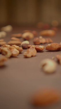 Kırsal ahşap bir yüzeye saçılmış çeşitli fındıkların yakın plan fotoğrafı, sağlıklı atıştırmalık temaları için ideal.
