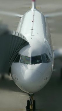 Burada, uçak pistte otururken burun ve kokpit alanını gösteren detaylı bir yakın çekim görüntüsü var.