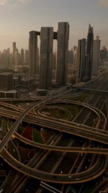 Havadan alınan görüntüler, arka planda yükselen gökdelenlerle iç içe geçmiş karmaşık bir otoyol sistemi gösteriyor.