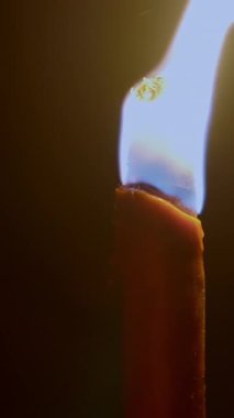 Titrek, titreyen bir mum alevi karanlıkta parlıyor, sıcaklığı, rahatlığı ve huzuru simgeliyor.