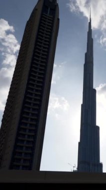 Burj Halife 'nin çarpıcı silueti etrafındaki binaların yanında bulutlu bir gökyüzünün altında güzel bir şekilde duruyor.