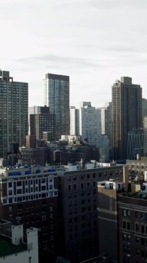 Nefes kesici ve çarpıcı bir manzara bulutlu bir gökyüzüne karşı yükselen binaların yer aldığı modern bir şehir siluetini gözler önüne seriyor.