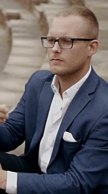 Şık giyinmiş genç bir adam bir sonraki hamlesini düşünüyor. Kendine güvenini ve profesyonelliğini gösteriyor.