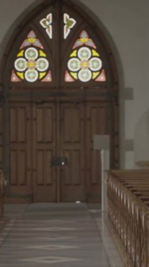 Bir kilise vitrininin zarif ahşap kapıları ziyaretçileri büyüleyen karmaşık vitray tasarımları.