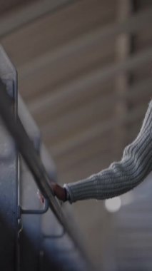 Çağdaş mimarideki destek ve bağlantıyı sembolize eden demiryolu üzerindeki bir elin odaklanmış görüntüsü.