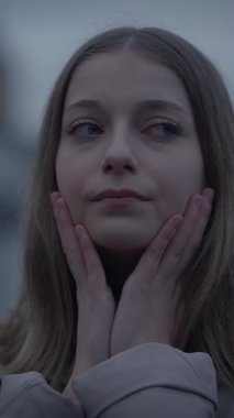 Düşünceli bir genç kızın sakin ve güzel bir portresi, sakin bir açık hava ortamında derin derin düşüncelere dalmış.