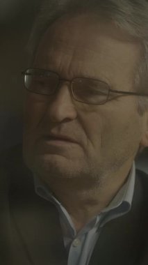 Düşünceli, yaşlı, gözlüklü, duygusal bir ana kapılmış, derin düşüncelere dalmış bir adam..
