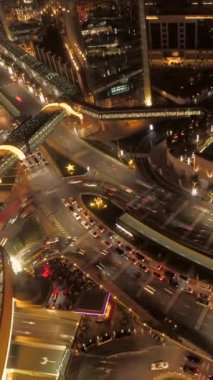 Canlı ve canlı bir şehir manzarası günbatımından sonra modern bir metropolün karmaşık trafik akışını canlı bir şekilde gösteriyor.