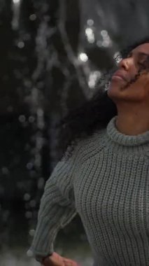 Doğanın güzelliğini kucaklayan neşeli bir kadın canlı kişiliğini gün ışığında dalgalanan saçlarıyla sergiliyor.