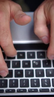 Modern bir dizüstü bilgisayarın klavyesinde daktilo yazan iki elin yakınlaşması, dijital bağlılık ve verimliliği gösteriyor