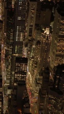 Göz kamaştırıcı bir hava görüntüsü, gece aydınlanan canlı şehir gökdelenlerini güzel bir şekilde yakalıyor.