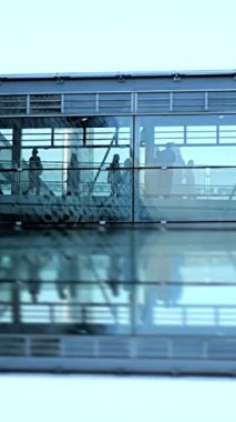 Gösterişli ve çağdaş bir havaalanı terminali yolcuların deneyimlerini yansıtmalarıyla birlikte sergiliyor.