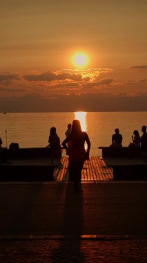 Şok edici bir günbatımı silueti sakin suya yansıyarak huzur ve huzur dolu huzurlu anları yakalıyor.