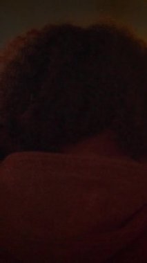 Yumuşak ışıklandırılmış bir ortamda derin bir bağ ve sıcaklık gösteren güzel, sıcak ve samimi bir sahne.