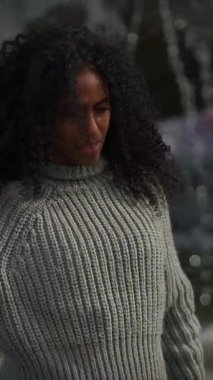 Canlı kıvırcık saçlı neşeli genç bir kadın doğada geçirilen güzel bir andan zevk alıyor.