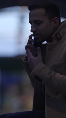 Profesyonel bir adam bir telefon görüşmesi yapar, alacakaranlıkta karamsar bir ortam yaratmak için güzel bir şekilde yakalanır.