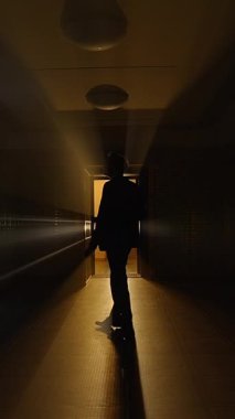 Rahatsız edici derecede karanlık bir koridor uzanıyor, sonunda işaret eden sıcak bir ışığa doğru, derin bir entrikayı çağrıştırıyor.