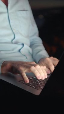 Dizüstü bilgisayarda güçlü bir şekilde yazan birden fazla elin yakın çekimi yoğun ve odaklanmış bir çalışma ortamı yaratıyor.