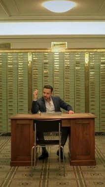 Zarif bir masada, kaliteli kiralık kasalarla çevrili, kaliteli profesyonel bir adam.