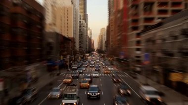 Gün batımında arabalarla ve gökdelenlerle dolu işlek bir şehir caddesi tüm ihtişamıyla şehir yaşamını ön plana çıkarıyor.