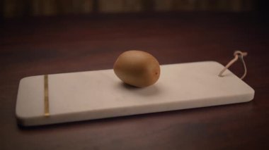 Zarif bir mermer tahtada sergilenen minimalist ahşap yumurta eşsiz bir ev dekorasyonu için mükemmel.