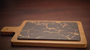 Bu şık, mermer desenli kesme tahtası, güzel bir ahşap tabanın üzerine kurulmuş, herhangi bir modern mutfak için mükemmel.