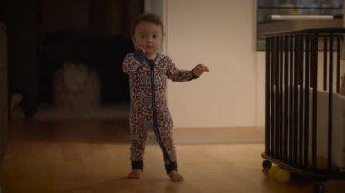 Neşeli ve tapılası bir bebek rahat pijama giyerken neşeli bir poz takınıyor ve evde geçirdiği zamanın tadını çıkarıyor.