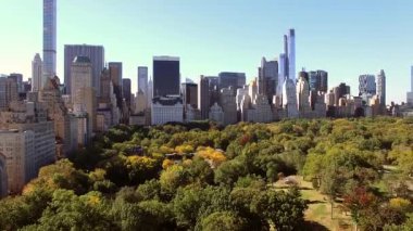 Central Park 'ın yemyeşil yeşilliğini gösteren nefes kesici bir hava manzarası New York siluetiyle yan yana.