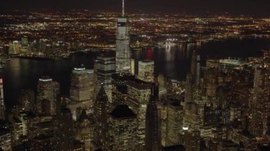 Gece nefes kesen panoramik bir manzara New York şehrinin ikonik siluetini canlı ışıklarıyla sergiliyor.