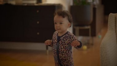 Renkli pijama giymiş şirin bir çocuk sıcak ve davetkar bir yaşam alanında güvenle yürüyor.