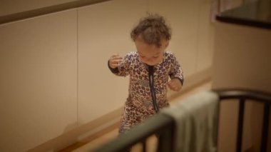 Sevimli kıvırcık saçlı meraklı bir çocuk sıcaklıkla dolu kapalı bir çevreyi inceliyor.