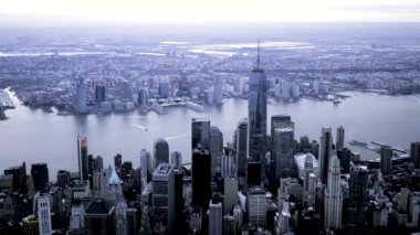 New York 'un ikonik gökdelenlerini ve alacakaranlıkta nehir manzarasını gösteren çarpıcı yüksek açılı bir fotoğraf..