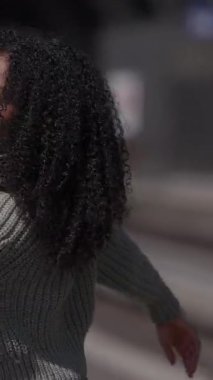 Güzel bukleli şık bir kadın. Saf bir güven anı yakalıyor. Sade örülmüş bir süveter.