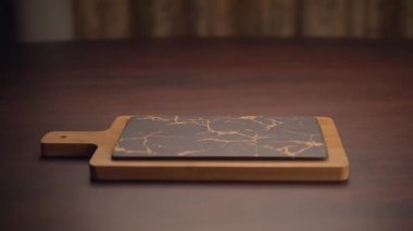 Sofistike mermer kaplamalı şık bir kesim tahtası ve zarif ahşap tabanlı mutfak estetiğini geliştiriyor.