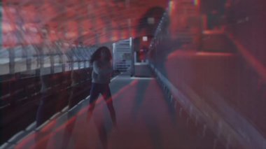 Çarpıcı kentsel ayar, canlı ve büyüleyici kırmızı ışığın arasında hareketli bir akışkan figürü gösteriyor.