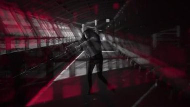 Cesur ve çarpıcı bir figür, kentsel bir ortamda büyüleyici bir kırmızı ve siyah zemin arasında güven içinde poz veriyor.