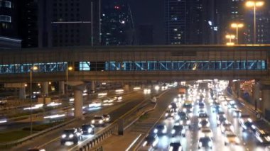 Parlak araba ışıkları, gökdelenler ve kalabalık bir şehirde yaya geçidi olan yoğun şehir trafiği..