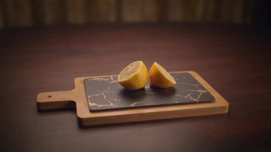 Bu estetik çekimde koyu mermer kesim tahtasında limon yarımları var. Yemek pişirmek için birebir.