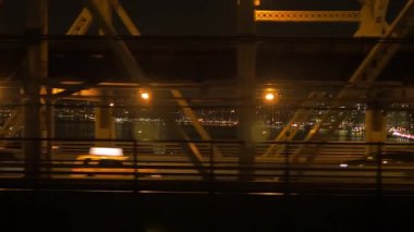 Parlak şehir ışıklarıyla aydınlatılan muhteşem bir köprünün çarpıcı gece manzarası enerjik bir kentsel titreşim sergiliyor.