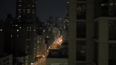 Hareketli ve parıldayan ışıklarla dolu canlı bir şehrin nefes kesici bir gece manzarası.
