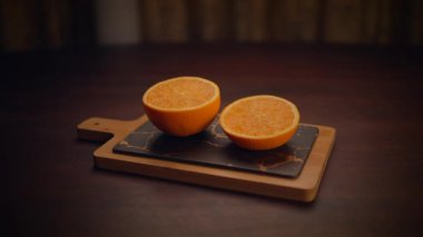 Kırsal ahşap bir tahtada sulu portakal parçaları sergileniyor. Mutfak ve sağlık projeleri için mükemmel.