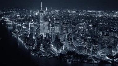 Gece vakti New York şehrinin göz kamaştırıcı ve canlı siluetini gösteren nefes kesici siyah beyaz bir hava fotoğrafı.