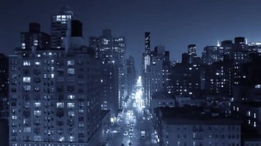 Nefes kesici gece manzarası aydınlık binalarla süslenmiş canlı bir şehir ve işlek bir sokak manzarası sergiliyor