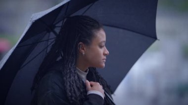 Yağmurlu bir atmosferde şemsiyesini tutan bir kadının güzel bir yansıması.