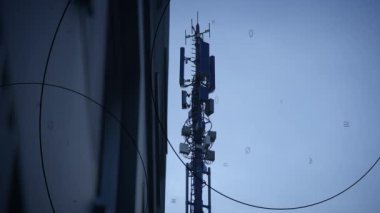 Bir telekomünikasyon kulesi, mavi gökyüzü zeminine karşı birden fazla anten ile modern bağlantıyı gösteriyor..